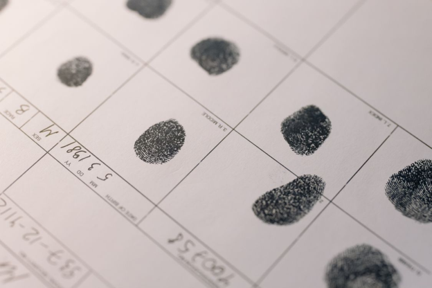 Several fingers print on a charge sheet.